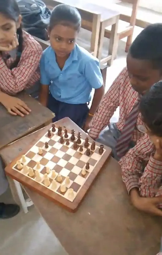 Best school in manigachhi, Indrathair and Darbhanga: Students at Apex International School actively engaging in a strategic game of chess inside a classroom. This top cbse school in Indrathair, Manigachhi & Darbhanga fosters critical thinking, problem-solving, and cognitive development through interactive indoor games and extracurricular activities. The image showcases three young students in uniform gathered around a wooden chessboard, focusing intently on making their next tactical move.As a leading top school in Indrathair, Manigachhi & Darbhanga, the institution prioritizes a balanced curriculum that combines rigorous academics with brain-stimulating games to build analytical minds. This focus on holistic student development makes it the best english school in manigachhi, Indrathair and Darbhanga for parents seeking all-around excellence. By encouraging logical reasoning skills early on, this top english school in Indrathair, Manigachhi & Darbhanga prepares its students for academic success and competitive exams in a supportive learning environment.