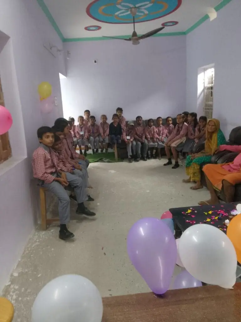 Best school in manigachhi, Indrathair and Darbhanga: Classroom celebration event at Apex International School featuring primary students gathered together. This top cbse school in Indrathair, Manigachhi & Darbhanga designs interactive classroom activities, student assemblies, and festive gatherings to promote peer bonding and social development. The image captures rows of young students in checkered uniforms seated along the walls of a brightly decorated room adorned with colorful balloons and overhead fans.As a premier top school in Indrathair, Manigachhi & Darbhanga, the academy balances strict learning schedules with lighthearted events to create an inviting, student-friendly atmosphere. This focus on standard classroom engagement helps rank it as the best english school in manigachhi, Indrathair and Darbhanga for parents prioritizing positive child growth within a nurturing, professional environment managed by the top english school in Indrathair, Manigachhi & Darbhanga.